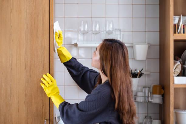 A Housewife Cleaning Wood Cupboard